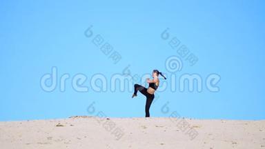 运动女孩穿着黑色的上衣和腿，练习踢腿，踢脚，和影子<strong>打架</strong>，训练<strong>打架</strong>。 在一个